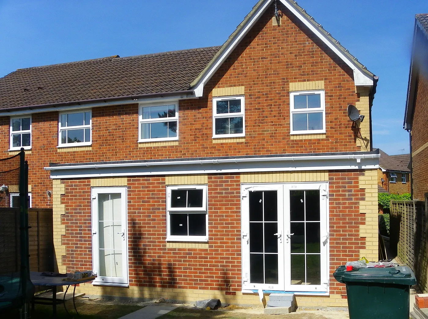 The finished single-storey extension from the garden, in brick matched to the house