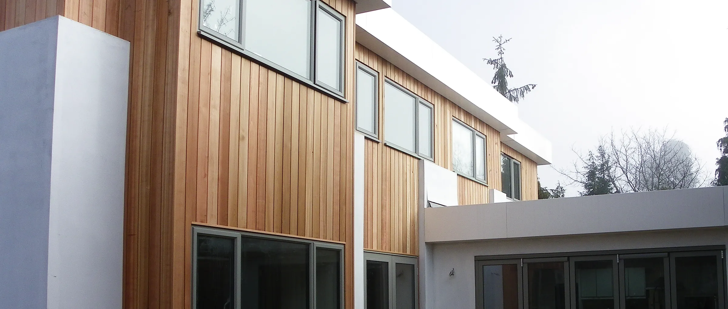 A finished contemporary remodel in cedar cladding and white render