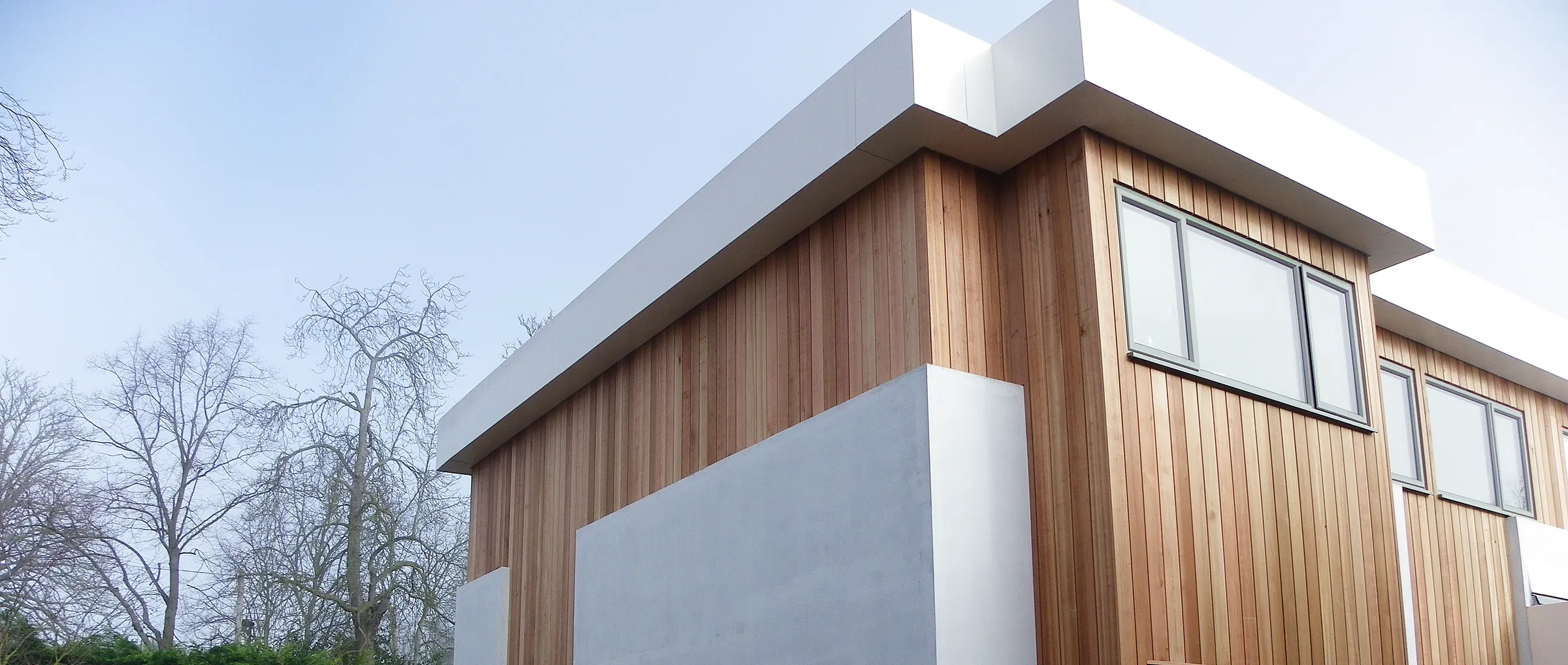A contemporary remodel by DC Carpentry & Construction, finished in white render and cedar cladding